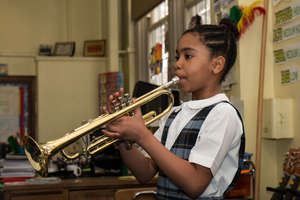 A student plays her trumpet proudly.