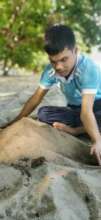 Dennis is playing with the sand, he feel it.