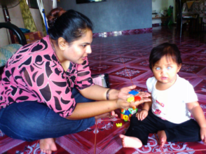 Teacher is showing Maira plastic alphabets for her