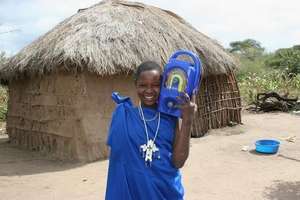 Salome with a radio outside her Masaai home