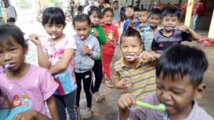 Kids practice brushing their teeth