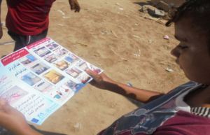 A child reads a hygiene pamphlet