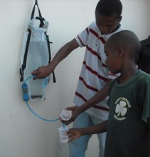 Dispensing water from a DayOne Waterbag in Haiti