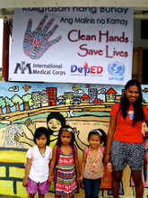 Mother, daughter and friends by a hygiene mural