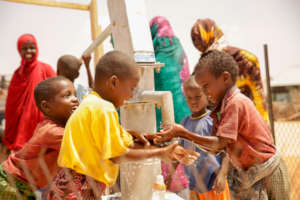Children of Qarsoodi pump water from the new well
