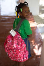 Elidania shows off her backpack of school supplies