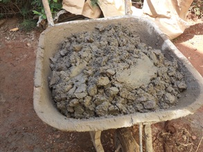 Concrete being mixed in a wheel barrow