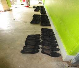 Shoes neatly arranged outside a classroom..