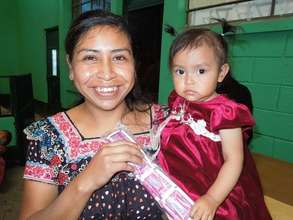 A mother receives "chispitas" for her baby