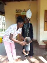Winnie weighing Pretty for a postnatal appointment