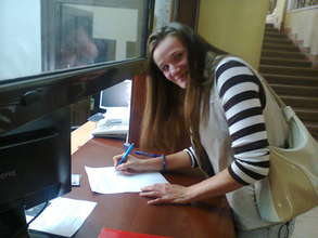 Aleksandra signing the contract for the house