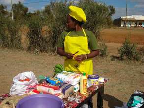 Jackline begins instructing on food preparation