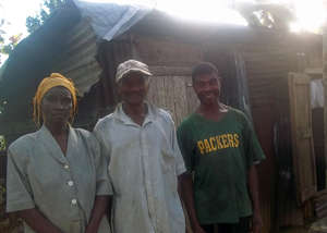 Mr. Maxi (center) outside his temporary shack.