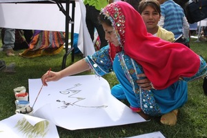 A girl paints at the Afghan Youth Voices Festival