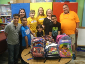 Volunteers donating back packs for school