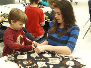 Maddie and a young volunteer maing blankets