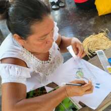 Artisan drawing a hummingbird for artisan workshop