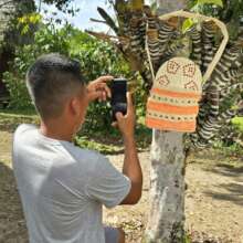 Artisan photographing a bag with leaf background