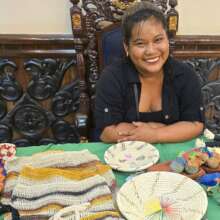 Artisan Claudia displaying her crafts at exhibit