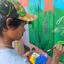 Bora artist Darwin painting mural at Brillo Nuevo