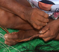 Artisan sewing wing onto tiger heron ornament