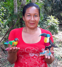 Artisan at Estiron workshop with parrot and toucan