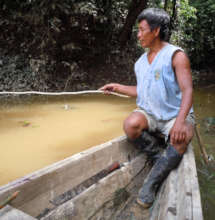 Bora man fishing from dugout canoe in Brillo Nuevo
