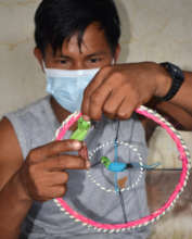 Brillo Nuevo artisan with woven bird mandala