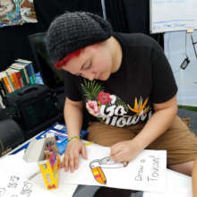 Tessa and the Draw a Toucan game at CACE booth