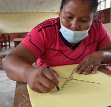 Bora artisan drawing native design on mandala