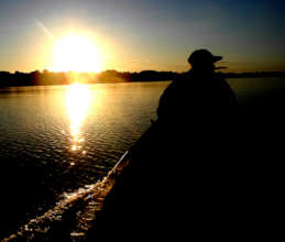 Bora man in boat at sunset