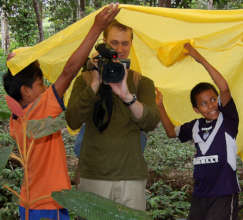 Greg and video camera in the rain with friends