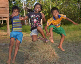 Bora children jumping over hay in Brillo Nuevo