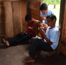 Bora artisan teaching how to make calabash rattles