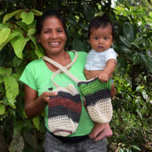 Nuevo Peru artisan with son and bottle carrier