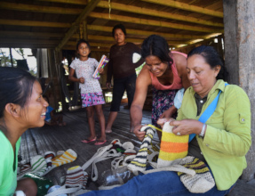 Yully reviewing crafts with Bora artisans