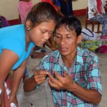 Pablo showing an artisan how to make a wire frame