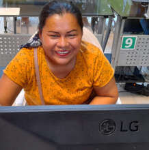 Artisan smiling behind a computer