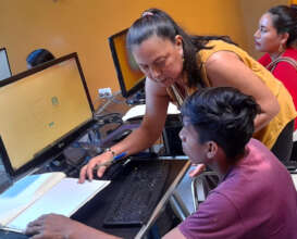 Amazon Ecology staff helping artisan at computer