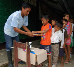 Bora man distributing school supplies from CACE