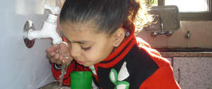 YOung girl drinking water from a Maia Unit