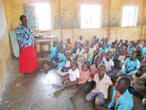 Children at school with teacher and no desks!