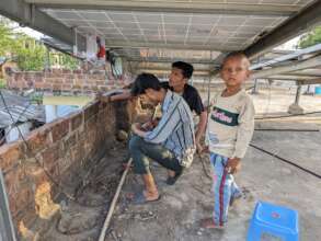 Two teenage solar students and a tiny apprentice