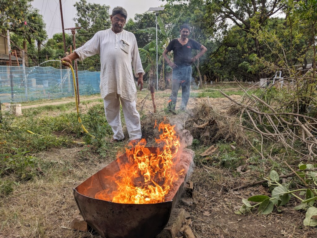 The primitive biochar kiln is working full steam