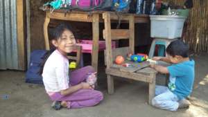 Carmeli and her little brother outside their home