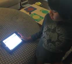 Aiden using his iPad mini at home
