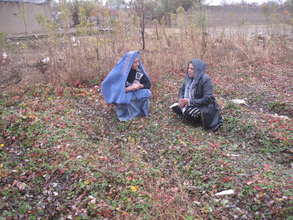 Staff visiting with farmer in her garden