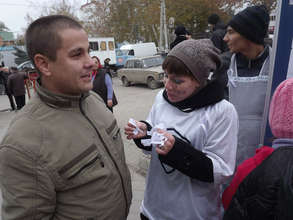 A volunteer offers white ribbons to passersby