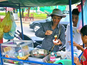 Cambodian woman serving food in a street market