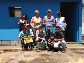 The family & volunteers in front of the new home